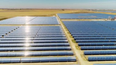 Güneş panelleri (güneş pili) olan bir çiftliğin 4 K Aerial görüntüsü. Güneş alanı üzerinde uçan yenilenebilir enerji konsepti