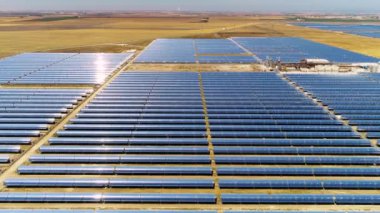Güneş panelleri (güneş pili) olan bir çiftliğin 4 K Aerial görüntüsü. Güneş alanı üzerinde uçan yenilenebilir enerji konsepti