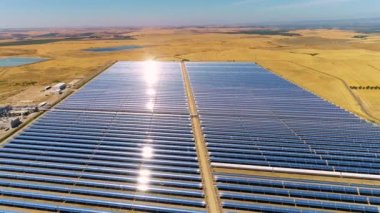 Güneş panelleri (güneş pili) olan bir çiftliğin 4 K Aerial görüntüsü. Güneş alanı üzerinde uçan yenilenebilir enerji konsepti