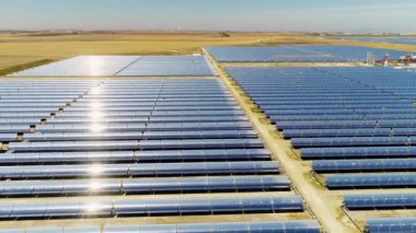 Güneş panelleri (güneş pili) olan bir çiftliğin 4 K Aerial görüntüsü. Güneş alanı üzerinde uçan yenilenebilir enerji konsepti