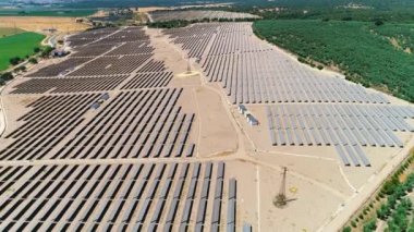 Güneş panelleri (güneş pili) olan bir çiftliğin 4 K Aerial görüntüsü. Güneş alanı üzerinde uçan yenilenebilir enerji konsepti