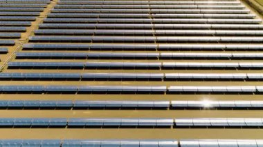 Büyük bir güneş çiftliğinin üzerinde uçan hava görüntüsü temiz ve yenilenebilir enerji yaratıyor.