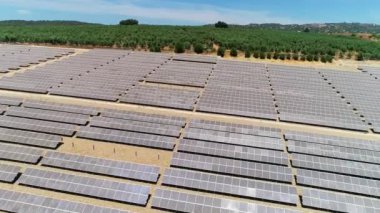 Güneş panelleri (güneş pili) olan bir çiftliğin 4 K Aerial görüntüsü. Güneş alanı üzerinde uçan yenilenebilir enerji konsepti