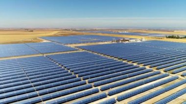 Güneş panelleri (güneş pili) olan bir çiftliğin 4 K Aerial görüntüsü. Güneş alanı üzerinde uçan yenilenebilir enerji konsepti