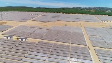 Güneş panelleri (güneş pili) olan bir çiftliğin 4 K Aerial görüntüsü. Güneş alanı üzerinde uçan yenilenebilir enerji konsepti