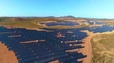 Güneş panelleri ve yenilenebilir enerji ile tarım. Arka planda rüzgar türbinleri olan İHA 'nın hava görüntüsü.