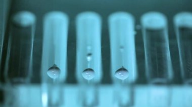 Laboratuvarda örnek tüpleri ve çalışan bir otomatik makine. Laboratuar makinesi beyaz bir laboratuvarda testler yapıyor. Yakın çekim. Bilim deneyi konsepti.