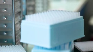 Laboratuvarda örnek tüpleri ve çalışan bir otomatik makine. Laboratuar makinesi beyaz bir laboratuvarda testler yapıyor. Yakın çekim. Bilim deneyi konsepti.