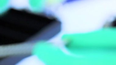 Yeşil eldivenli bir bilim adamı laboratuardaki numune tüpleriyle test ve araştırma yapıyor. Sadece beyaz bir laboratuvarda bulunan mikrobiyologların ellerini görebiliyoruz. Yakın çekim görüntüsü. Bilim deneyi konsepti