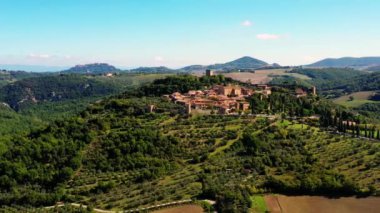 İnsansız hava aracı muhteşem otantik bir İtalyan köyü ve yeşil çayırlar üzerinde uçuyor. İtalya 'nın Monticchiello Tuscany kasabasının hava manzarası.