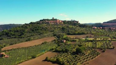 İnsansız hava aracı muhteşem otantik bir İtalyan köyü ve yeşil çayırlar üzerinde uçuyor. İtalya 'nın Monticchiello Tuscany kasabasının hava manzarası.