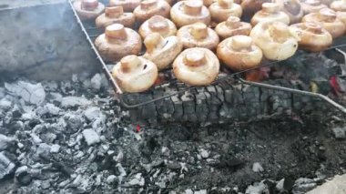 Şampiyon mantarları mangal rafında açık ateşte kömürle pişirilir..