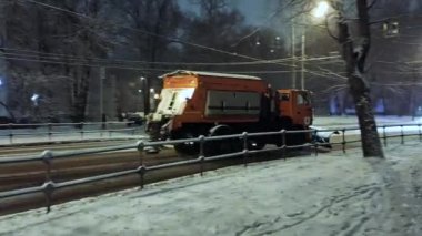 Bir ambulansın ve temizlik malzemelerinin yol aldığı kar yağışı sırasında şehrin karla kaplı yolu..