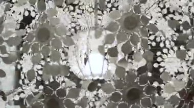 Tavandan sarkan büyük cam lambalı beyaz plastik bir avize..