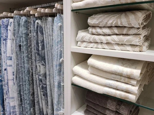 Vista de um guarda-roupa com cobertores de lã pendurados em cabides e toalhas terry nas prateleiras. — Fotografia de Stock