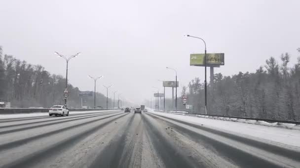 Росія. Москва. 31.01.2021 Вид через вітрове скло автомобіля на Московській кільцевій дорозі взимку в снігопаді. — стокове відео