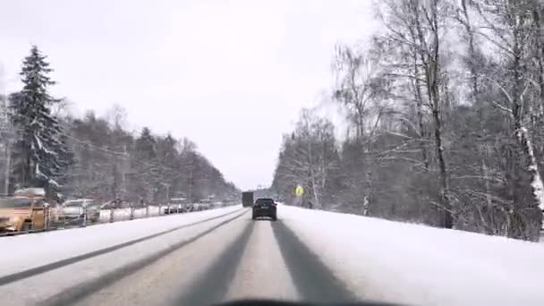 Rosja. Moskwa. 31.01.2021 Widok przez przednią szybę samochodu na autostradzie Jarosławia zimą w śniegu. — Wideo stockowe