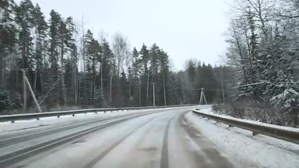 Vista através do pára-brisas de um carro que faz uma curva em uma estrada escorregadia na floresta. — Vídeo de Stock