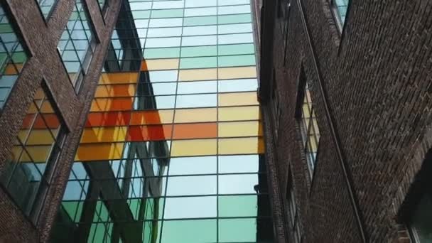 Pohled na moderní cihlovou budovu s barevnými skleněnými prvky.. — Stock video