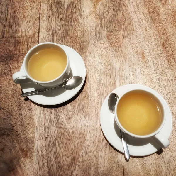 Dos Tazas Están Platillos Blancos Una Mesa Madera — Foto de Stock