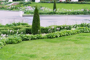 Landscaping in a park with flower beds of various shapes, walking paths and trimmed bushes