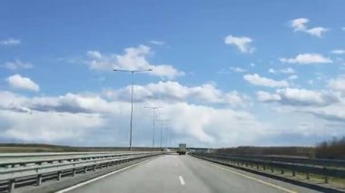 Zaman turları. Güneşli bir havada St. Petersburg Moskova Otobanı 'nda giden bir arabanın ön camından bakın..