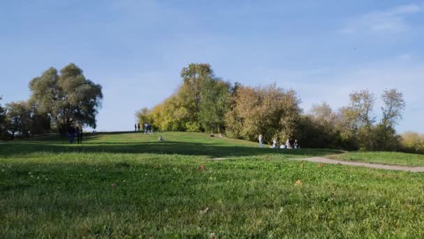 06.10.2021 Moskau. Russland. Blick auf junge Leute zu Fuß in Kolomenskoje Park auf grünen Rasenflächen im Herbst. — Stockvideo