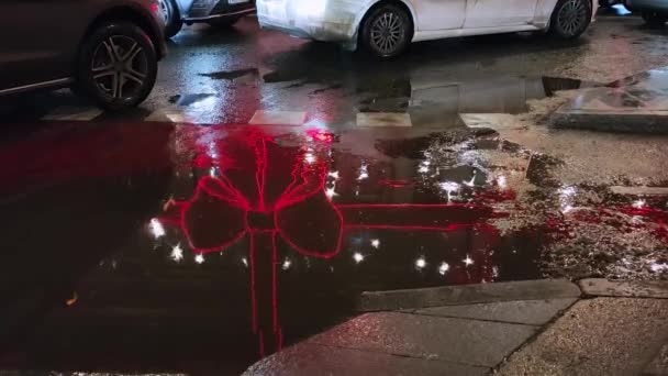 Vista di auto in piedi in un ingorgo e una pozzanghera in cui si riflette l'illuminazione natalizia. — Video Stock