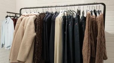 Mağazadaki moda bir renk paletinde sonbahar koleksiyonu olan bir rafın üst görüntüsü.