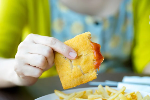 Frauen essen in Fast-Food-Restaurant gebratenen Fisch in der Hand — Stockfoto