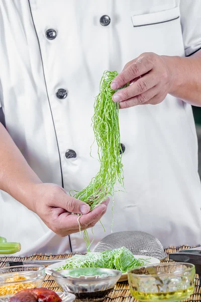 Chef sosteniendo fideos verdes — Foto de Stock