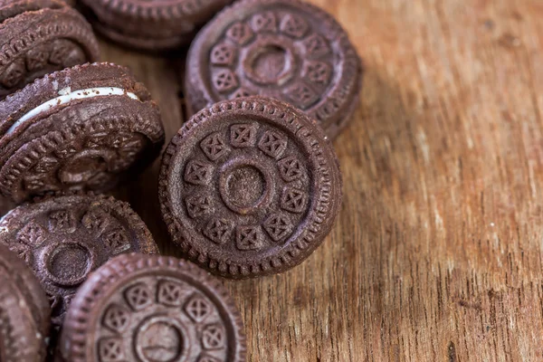 Čokoládové cookies s crème na dřevěný stůl — Stock fotografie