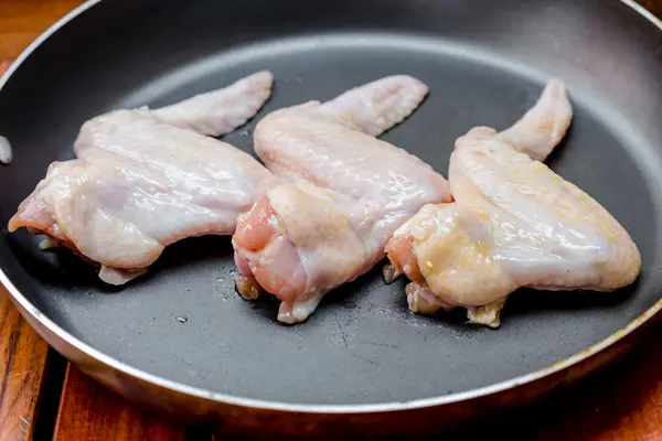 Ailes de poulet crues dans la poêle — Photo