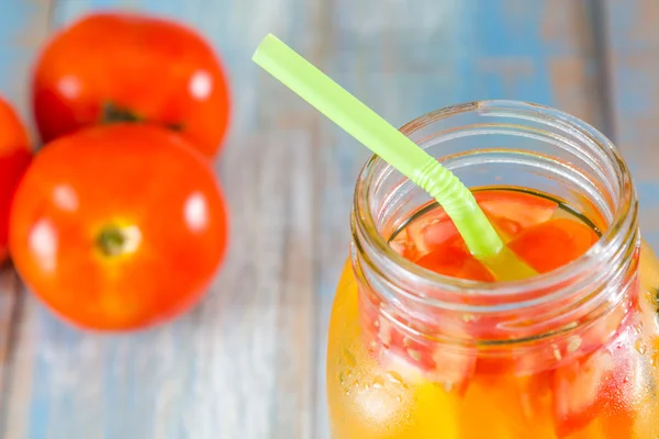 Citrus fruits and kiwi, tomato in pitcher — Stock Photo, Image