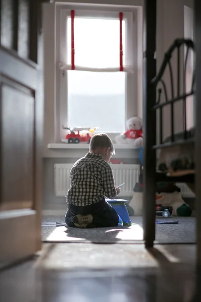 Üzgün çocuk tek başına bir çocuk odasında