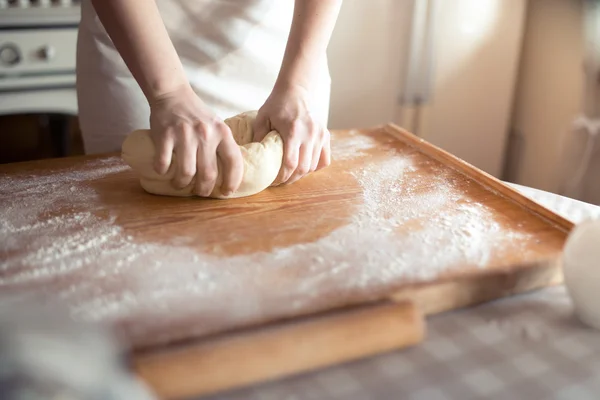 Baker handen kneden deeg in bloem op tafel — Stockfoto