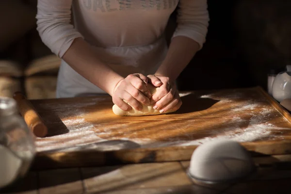 Fırıncı elleri masada un içinde hamur yoğuruyor.