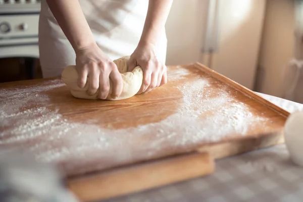 Padeiro mãos amassar massa de farinha na mesa — Fotografia de Stock