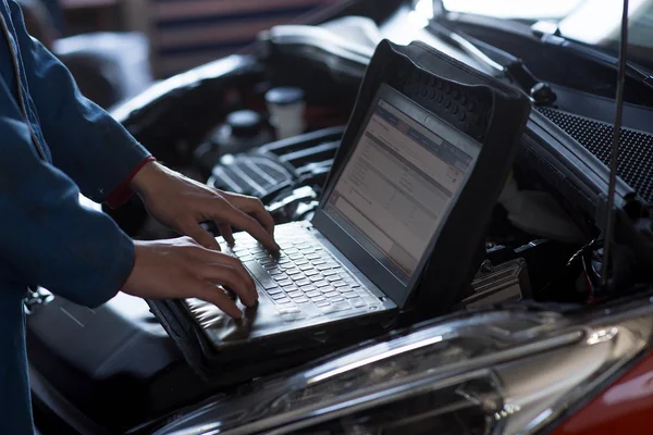 Araba tamircisi oto tamir servisinde çalışıyor.