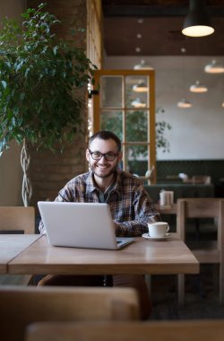 Genç adam sokakta tablet bilgisayar kullanırken kahve içme