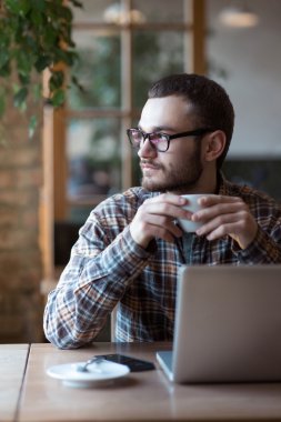 Genç adam sokakta tablet bilgisayar kullanırken kahve içme