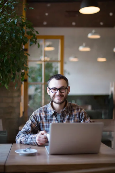 Genç adam sokakta tablet bilgisayar kullanırken kahve içme