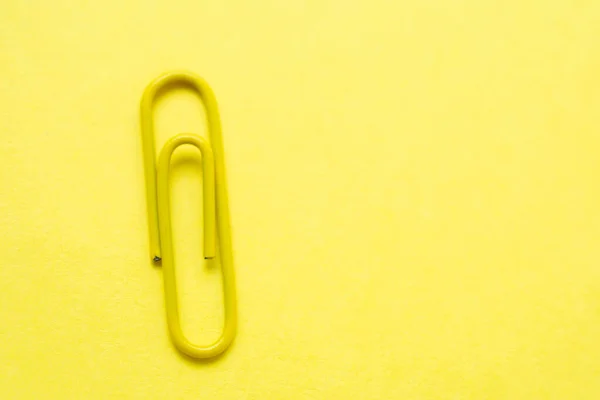 Gele Paperclip Een Felgele Achtergrond Met Kopieerruimte Aan Rechterkant Van — Stockfoto