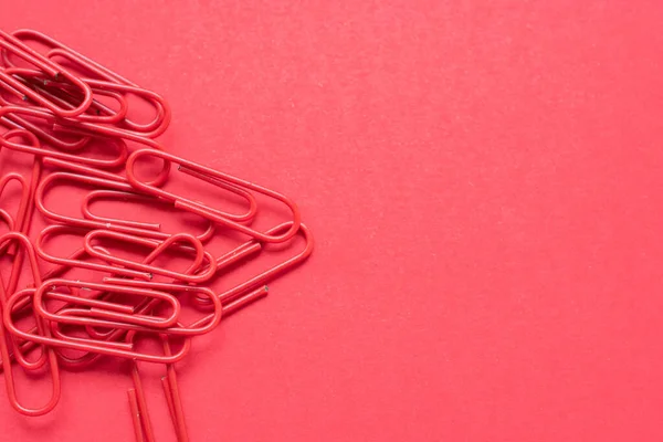 Rode Paperclips Een Kersenrode Achtergrond Aan Linkerkant Met Kopieerruimte — Stockfoto