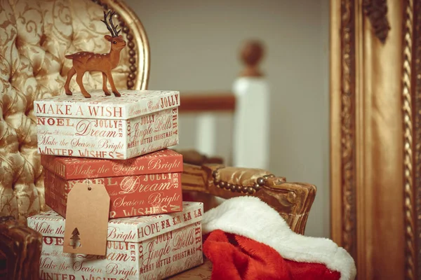 驯鹿坐在堆放的圣诞礼物之上 — 图库照片