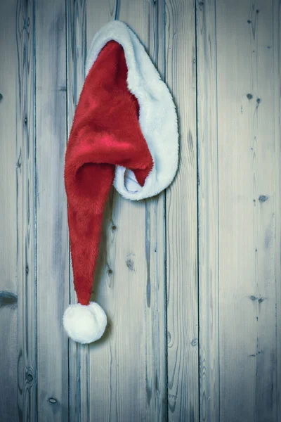 Kerstman Hoed Ophangen Aan Rustieke Houten Deur — Stockfoto