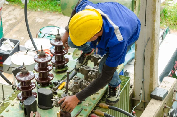 Gli elettricisti stanno esaminando trasformatori elettrici di potenza . — Foto Stock