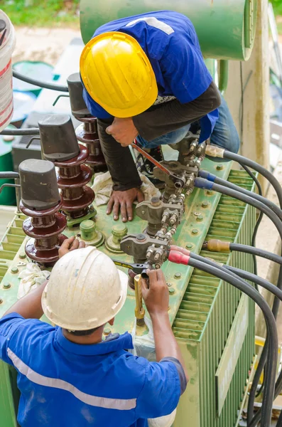 Los electricistas examinan transformadores eléctricos de potencia . — Foto de Stock