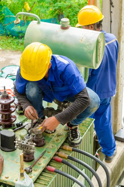 Gli elettricisti stanno esaminando trasformatori elettrici di potenza . — Foto Stock