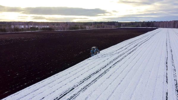 Ein Blauer Traktor Pflügt Ein Schneebedecktes Feld Hinter Dem Traktor — Stockfoto